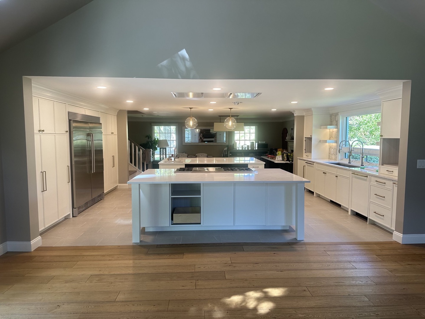 A Renovar kitchen with cabinets finished in white against soft sage-gray walls